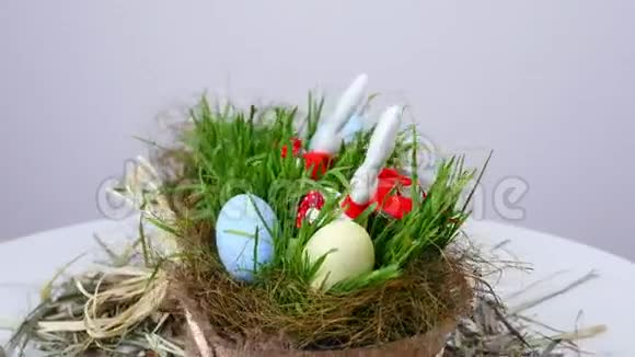 在白色的背景下旋转节日复活节由彩蛋绿色的幼草和柔软的组成视频的预览图