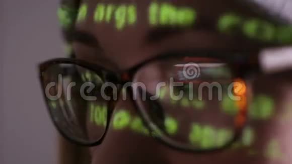 戴眼镜的女人在黑暗中在电脑上工作视频的预览图