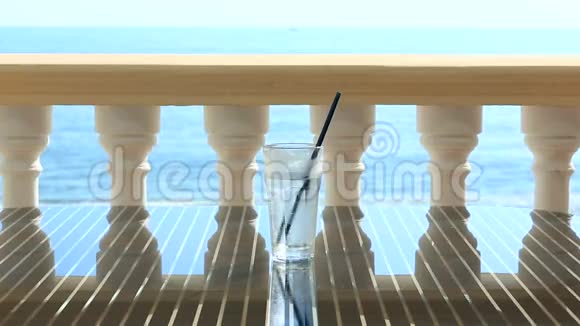 餐厅桌上放着一杯冰的水俯瞰大海在海浪的背景下复制空间视频的预览图