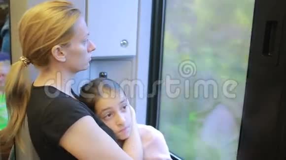 移民母亲和女儿在火车的窗户里寻找视频的预览图
