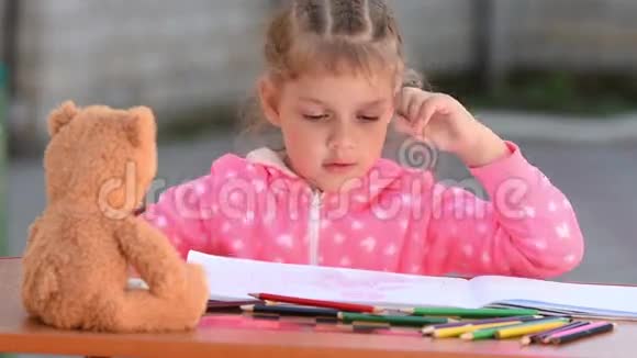 五岁的女孩在一张专辑中选择想要的彩色铅笔画视频的预览图