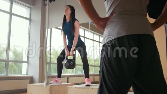 女人在健身房里做有重量的蹲视频的预览图