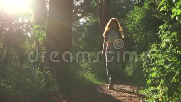 布鲁内特女孩走向相机在日落针叶林放大慢镜头视频的预览图