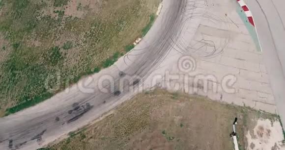 空中镜头赛车赛道与角冠军驾驶电影看沥青燃烧轮胎阴天高速co视频的预览图
