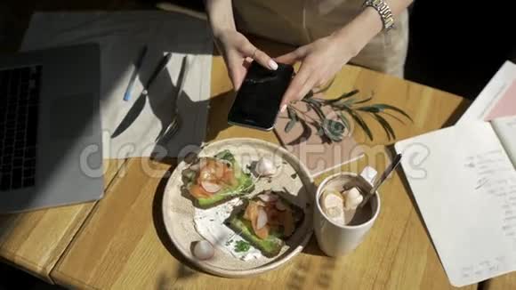 手拿手机特写食物图片两人早餐三明治咖啡吐司视频的预览图