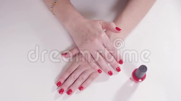 美容院白色桌子上有美甲和红漆的女性手一个年轻女人的特写视频的预览图