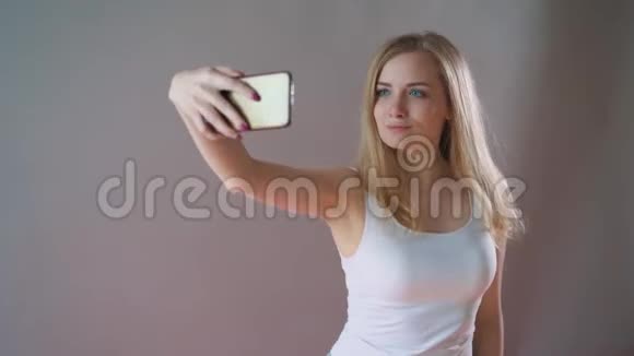 淡妆的美女在灰色背景上自拍视频的预览图