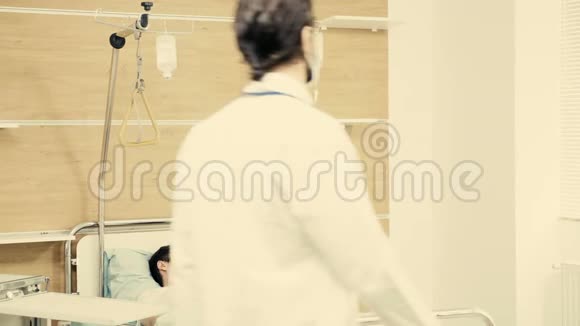 年轻医生照顾一个睡在床上的病人视频的预览图