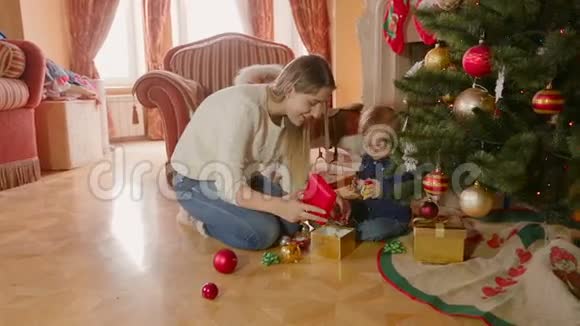 年轻的母亲在客厅的圣诞树下玩耍视频的预览图