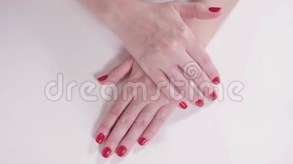 美容院白色桌子上有美甲和红漆的女性手一个年轻女人的特写视频的预览图