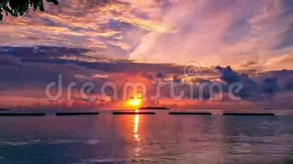 在马尔代夫的岛屿上五颜六色的日落时间随着橙色的天空乌云和地平线上的岛屿而流逝视频的预览图