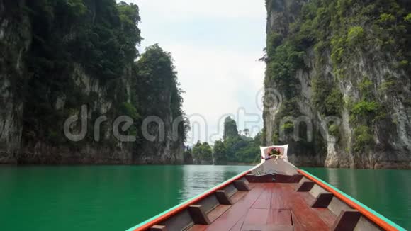 传统的木长尾船鼻子从水中升起的石灰石悬崖的正面景观位于视频的预览图