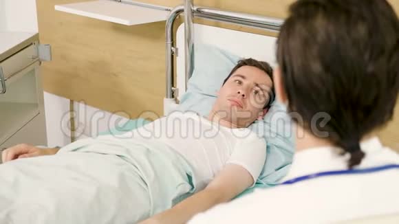 年轻医生照顾一个睡在床上的病人视频的预览图