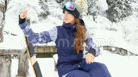 滑雪板女孩在阿尔卑斯山用手机自拍视频的预览图