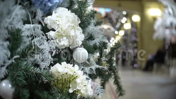 白色的球和花新年和抽象模糊的购物中心背景与圣诞树装饰视频的预览图