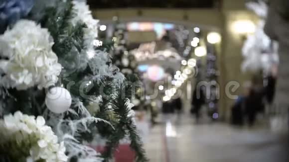 白色球和花的滑动视图新年和圣诞树模糊的购物中心背景视频的预览图