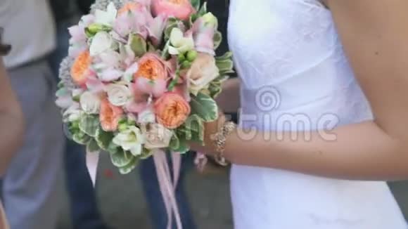 新娘在户外手持新娘花束的特写镜头视频的预览图