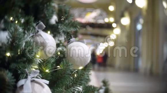 白色羊毛球和灯的滑动视图新年和圣诞树模糊的购物中心背景视频的预览图