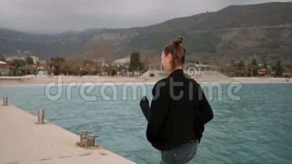 发型滑稽的女人在海边的码头上奔跑视频的预览图