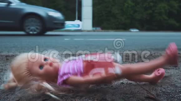 娃娃落在道路附近交通活跃许多汽车从后面来慢动作视频的预览图