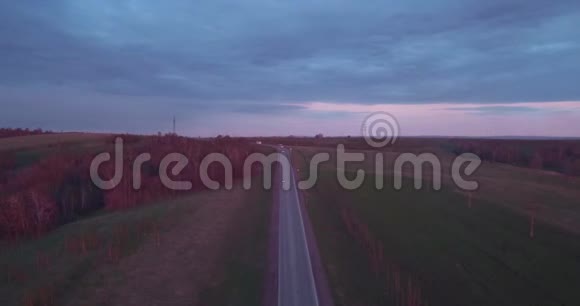 空中景观乘坐高速公路卡车和几辆汽车在日落和云彩4K视频的预览图