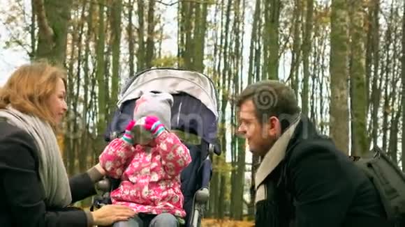 小女孩和她的父母在秋天公园喝着热气腾腾的茶家庭野餐快乐4克斯泰德姆视频的预览图