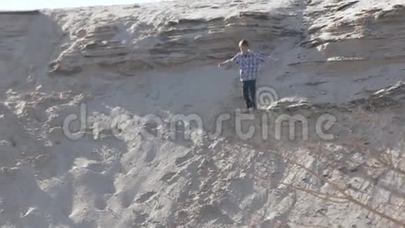 一个孩子在一座高沙山上奔跑慢动作视频的预览图