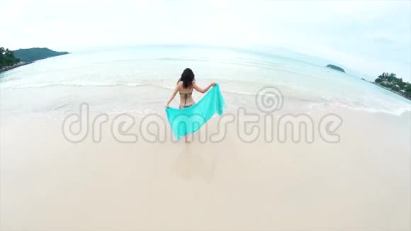 带着面纱走向大海的年轻女孩旅行者视频的预览图