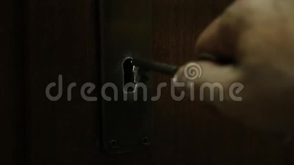 骷髅钥匙进入旧锁孔锁一扇打开的门揭示了一道天光视频的预览图