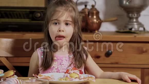 小女孩装饰和吃美味的纸杯蛋糕视频的预览图