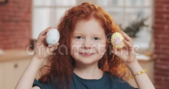欢快的红头小女孩在厨房背景上玩复活节彩蛋的肖像她在欢呼视频的预览图