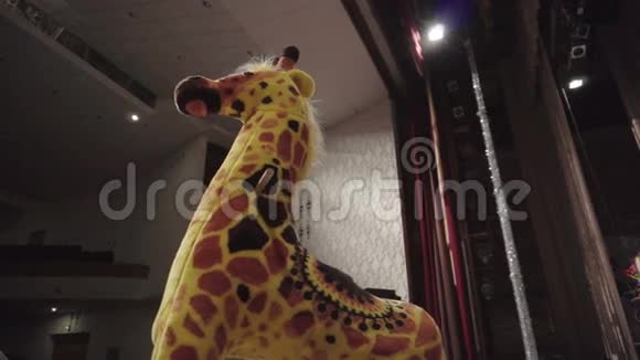 玩具长颈鹿站在舞台上摇摆视频的预览图