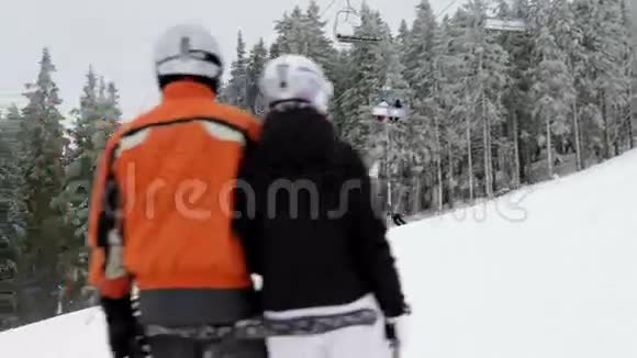 站在滑雪坡边缘的年轻夫妇视频的预览图