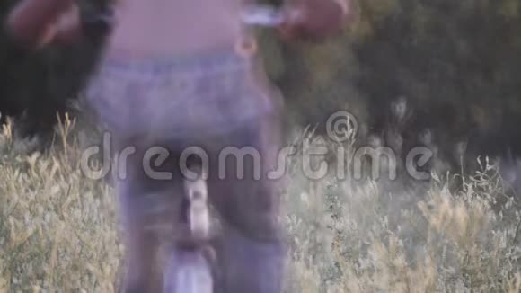孩子们在一个村庄里休息骑着自行车在高高的草地上视频的预览图