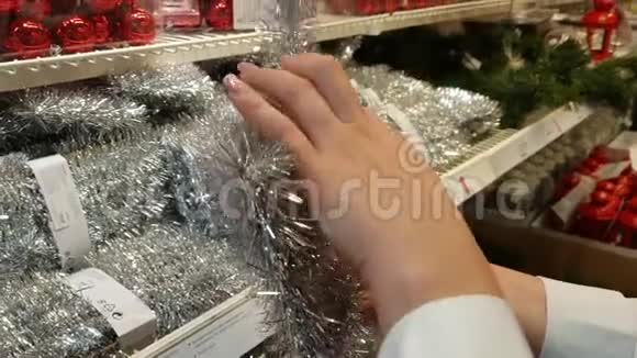 年轻女子在商店里挑选圣诞树装饰品视频的预览图