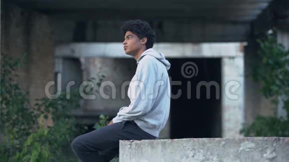 沮丧孤独的黑人男性坐在废弃的建筑思考问题视频的预览图