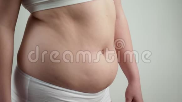 穿白色内衣的女人抱着她的腹部脂肪视频的预览图