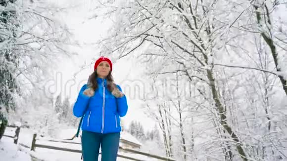 女人沿着一条小路走在美丽的冬天白雪覆盖的风景中晴朗晴朗的霜冻天气视频的预览图