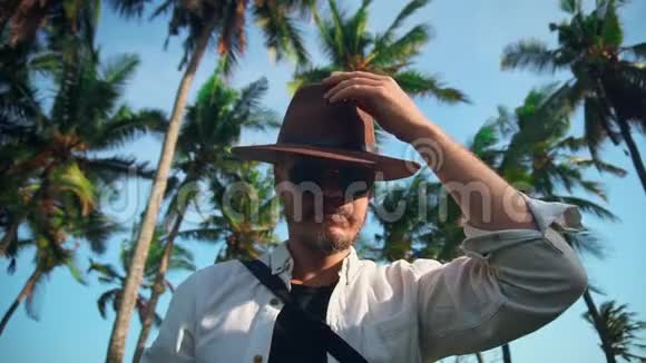 一个积极的年轻人戴着帽子背着一个背包为了椰子棕榈假期对新的冒险感到高兴视频的预览图