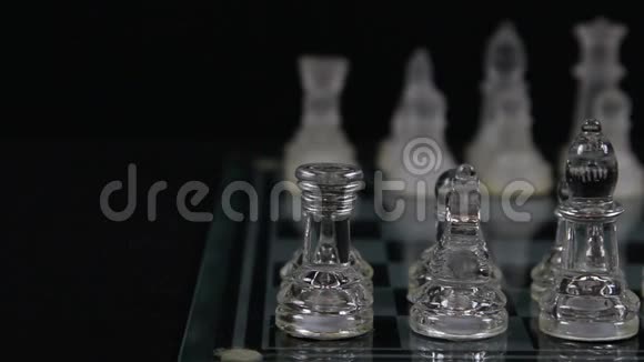 玻璃棋手在黑背景的棋盘上的起始位置视频的预览图