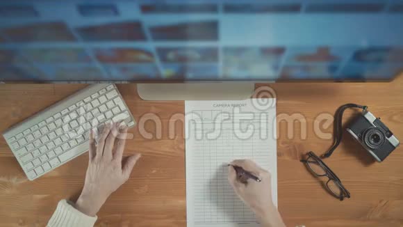 摄影师使用显示器和键盘从电脑显示器中选择照片顶部视图视频的预览图