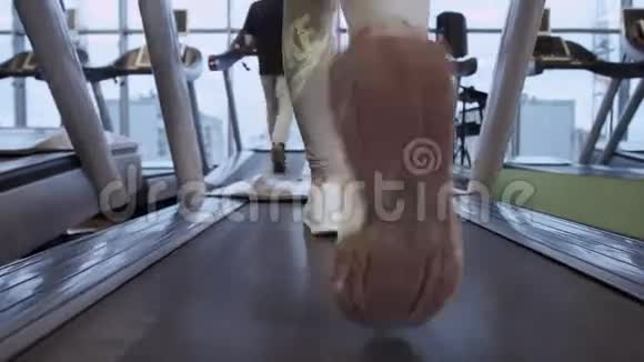 跑步机健身房里跑步的女性腿部特写视频的预览图