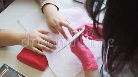 女人的手在美容院接受美甲打钉子特写选择性聚焦视频的预览图