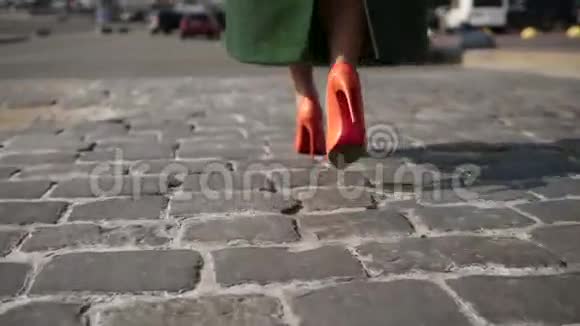 女人的腿走在鹅卵石街道上视频的预览图
