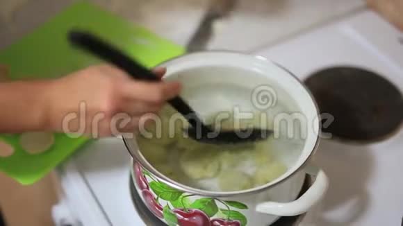 女孩在锅里煮饺子女孩准备食物视频的预览图