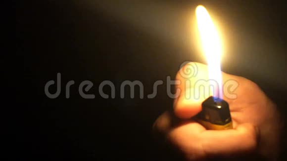 一个人在黑暗中点燃打火机的特写镜头视频的预览图