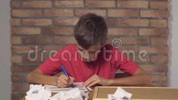 坐在办公桌前的孩子拿着一张挂图背景红砖墙上有字母错误视频的预览图
