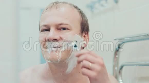 一个男人在浴室里刮胡子慢动作视频的预览图
