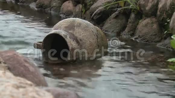 在一个纯净水背景下的小溪里的老水壶视频的预览图