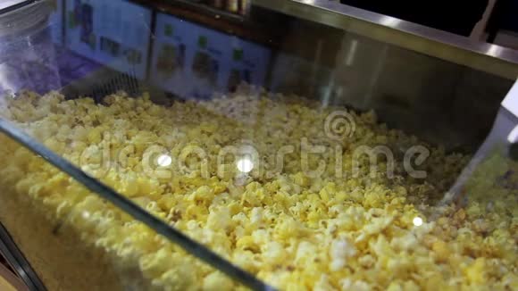 在cimena电影院用奶酪焦糖爆米花炸玉米装人手装大塑料桶的特写镜头视频的预览图